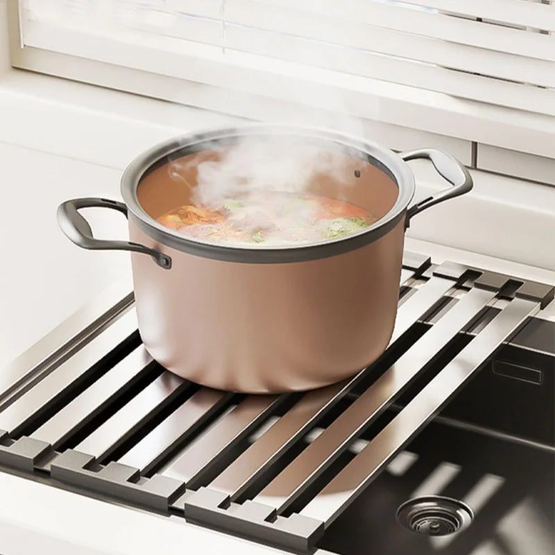 Hand placing hot cookware on heat-resistant over-sink drain rack surface during cooking