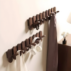 Coat rack in use with white coats and canvas bags hanging from hooks