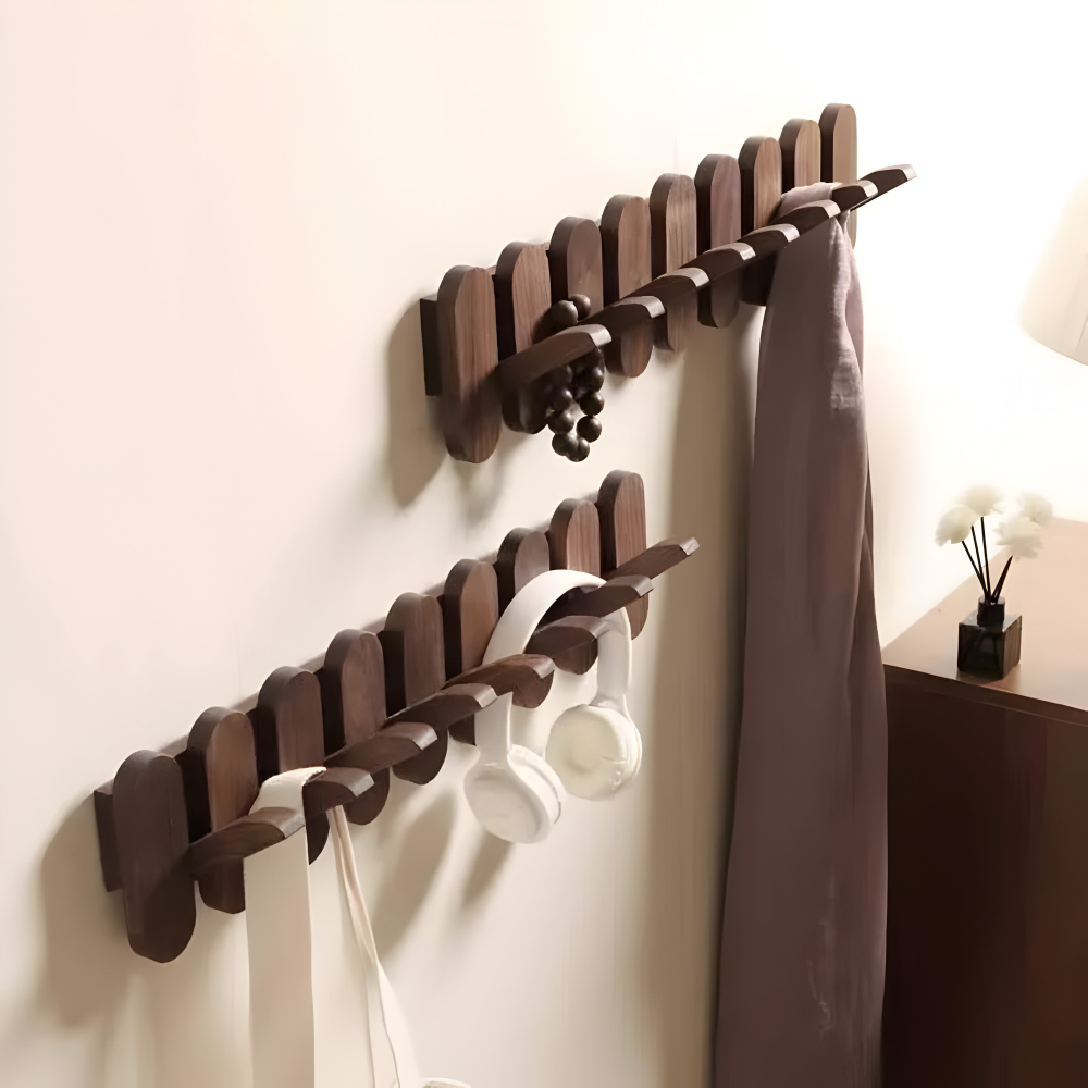 Coat rack in use with white coats and canvas bags hanging from hooks