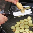 Hand cutting vegetables with kitchen scissors directly into red cooking pot
