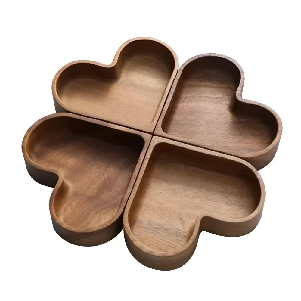 Overhead flat-lay of four walnut wooden snack bowls on linen tablecloth each filled with different snacks including pistachios and walnuts