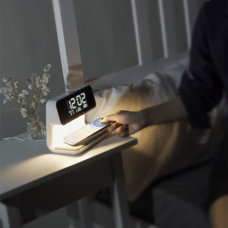 Close-up LCD screen showing time date weekday temperature on white bedside charging lamp