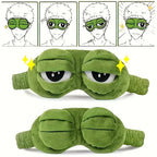 Two green frog eye sleep masks laid side by side on white linen surface showing pack of 2 contents