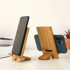 Bamboo phone stand on bedside table beside a ceramic mug and small potted plant in a minimal AU home interior