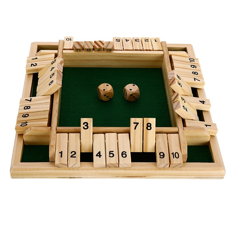 Two adults mid-game on Shut the Box wooden dice game with several numbered tiles flipped down on timber table