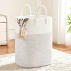 Woven cotton laundry basket 100L capacity shown in use filled with soft toys, braided handles visible, natural light setting