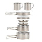 Stainless steel camping pan with grilled steak and sliced vegetables on a wooden outdoor camp table