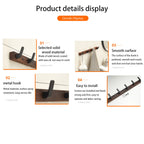 Underside of walnut wood coat rack showing screw mount hole and round black cap cover on white wall