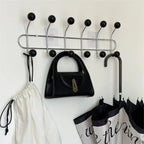 Wide entryway with apricot ball hook coat rack beside shoe rack and console table in styled Australian home interior