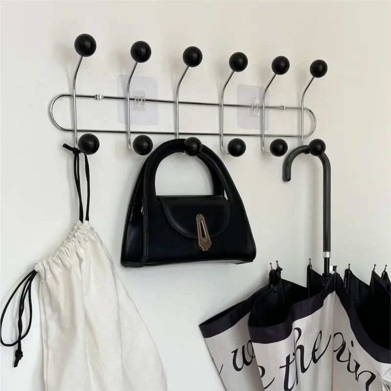 Wide entryway with apricot ball hook coat rack beside shoe rack and console table in styled Australian home interior