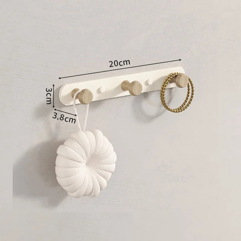 Close-up detail of smooth rounded wooden knob hook and carbon steel rail, natural wood grain texture visible