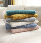 Hands demonstrating anti-slip mat placement under teddy fleece sofa cover installation guide