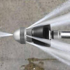 Close-up macro detail of stainless steel drain nozzle spray tip showing precision jets and brushed metal finish