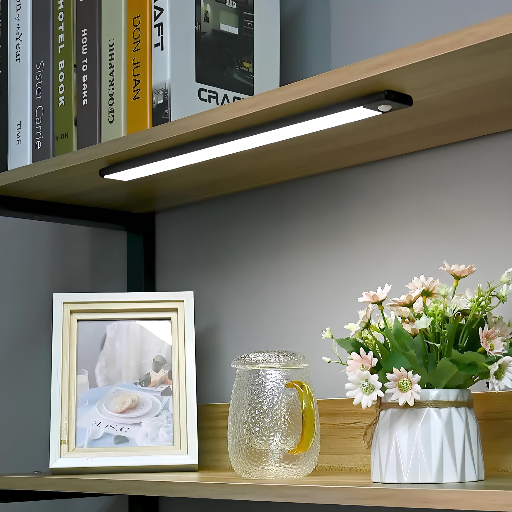 Hand installing motion sensor LED light under shelf using magnetic mount no drilling